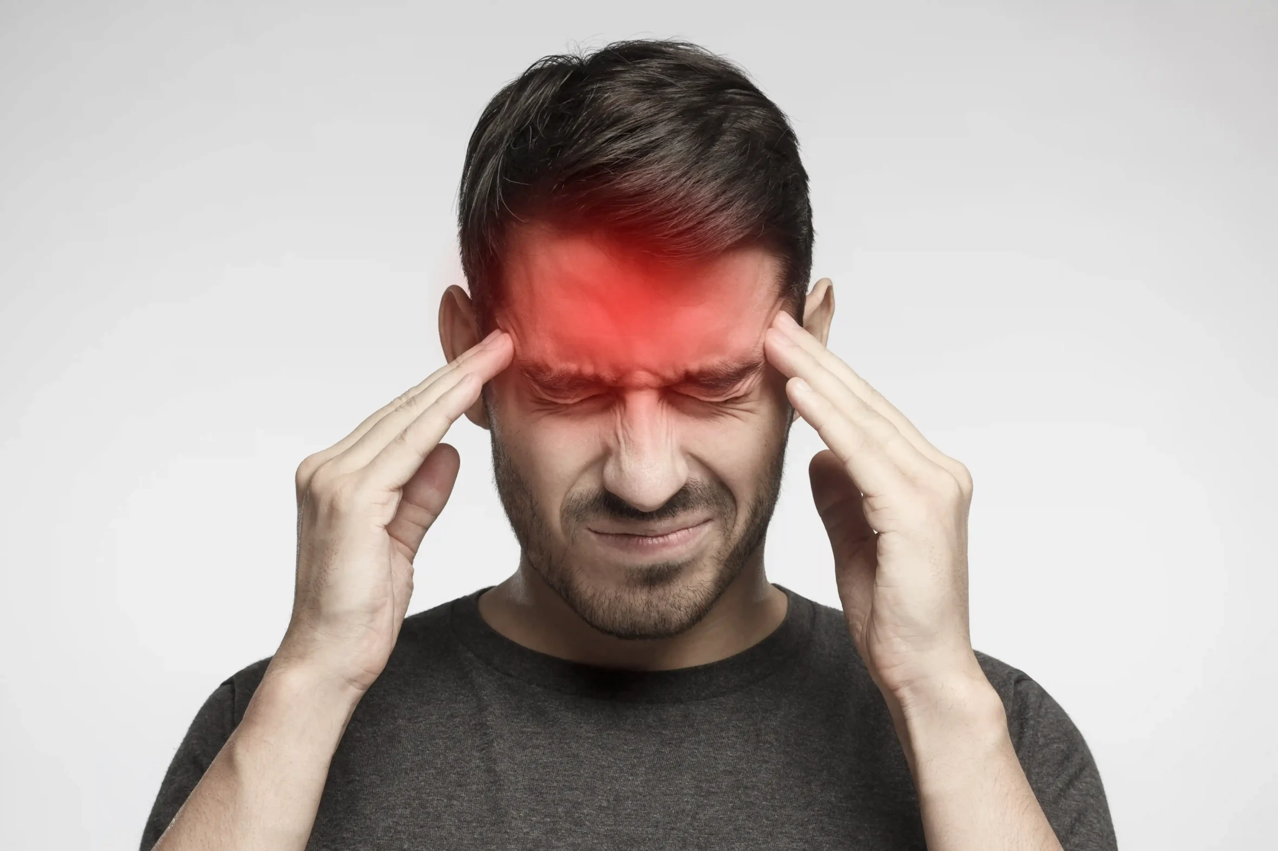 Man experiencing a headache looking for trigger point therapy and massage therapy.