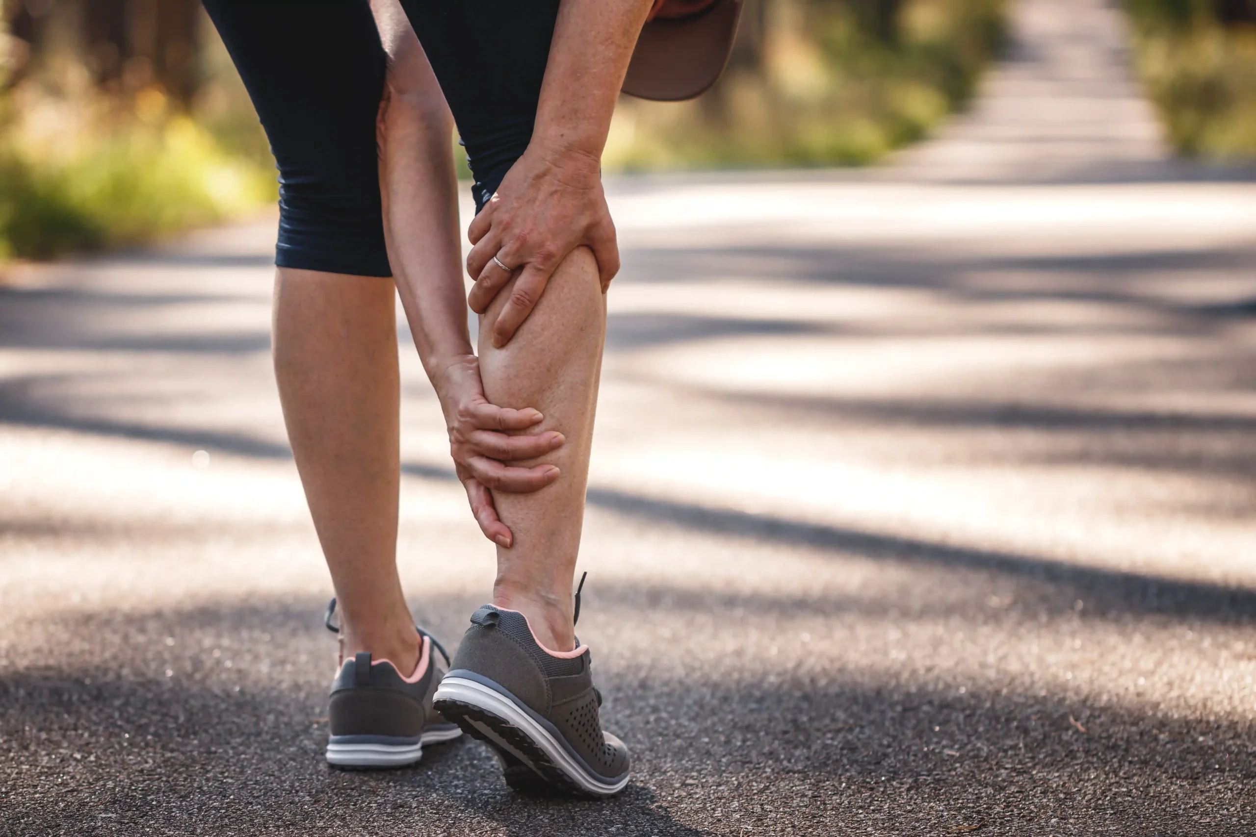 A runner with a calf strain needing cold laser therapy, massage therapy, and muscle stimulation (e-stim) treatments.