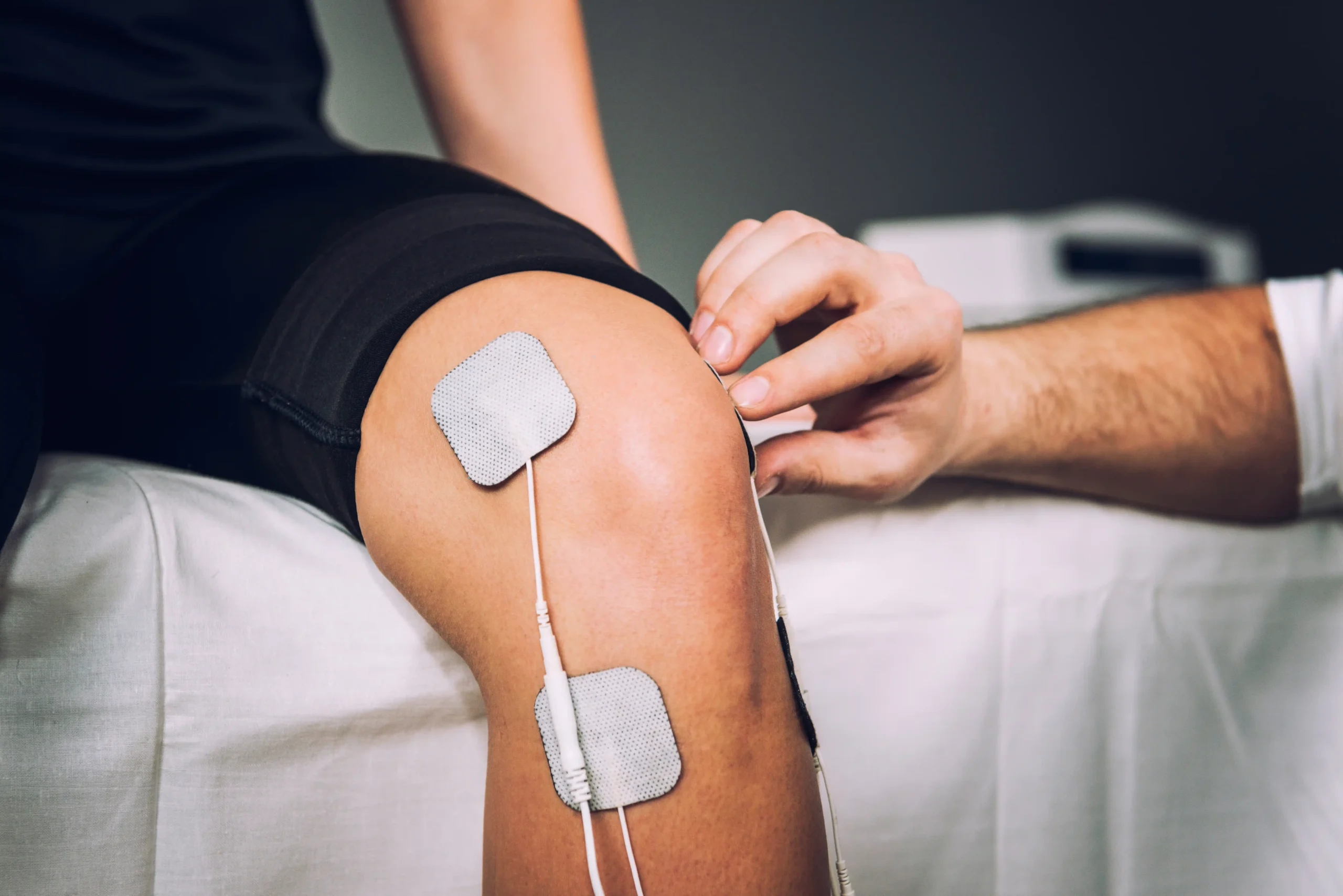 A chiropractor in Chapin, SC hooking a patient up to an Electronic Muscle Stimulation Therapy.