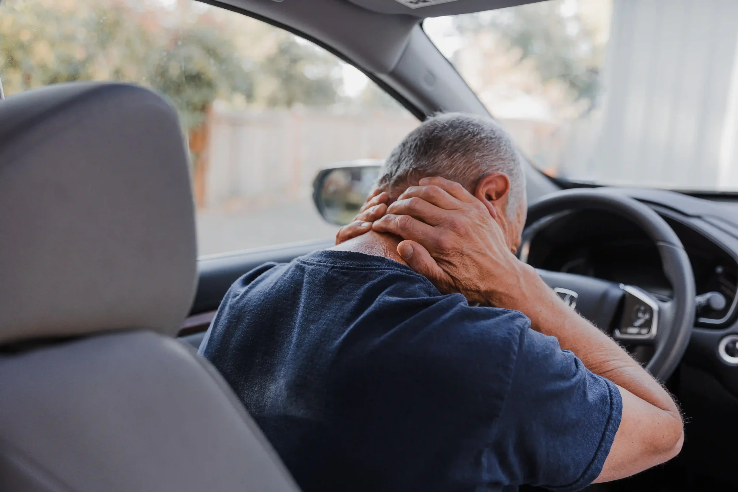 man in an auto accident experiencing whiplash in his neck.